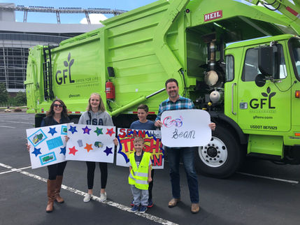 Make A Wish event participants holding posters in front of a truck