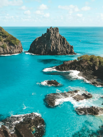Duas montanhas, sob mar azul turquesa.