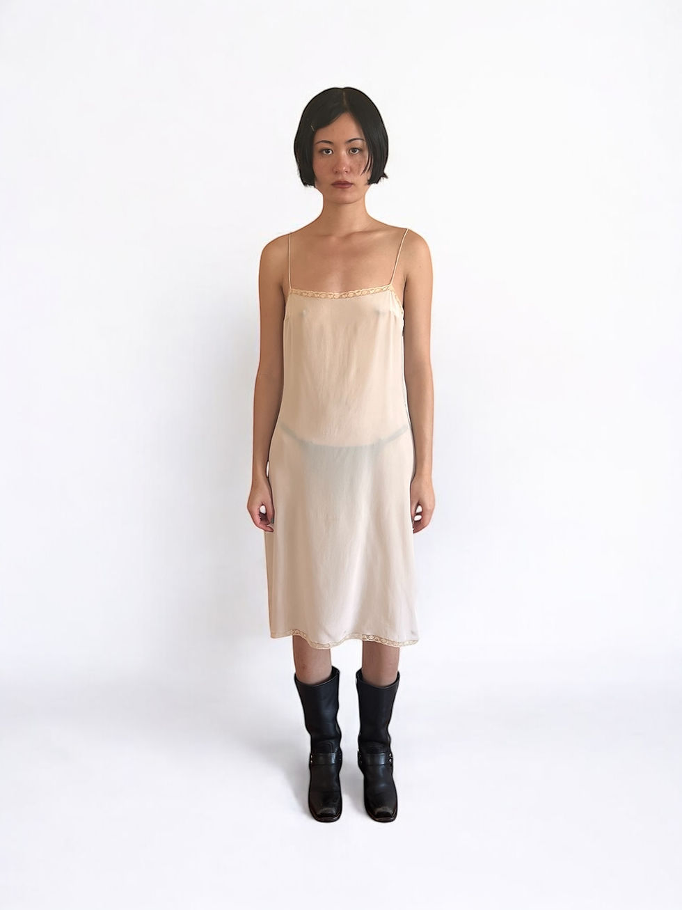 Woman wearing a nude slip dress and black boots