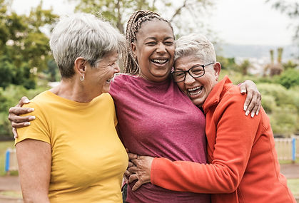 Happy multiracial senior women having fun together outdoor - Elderly generation people hug