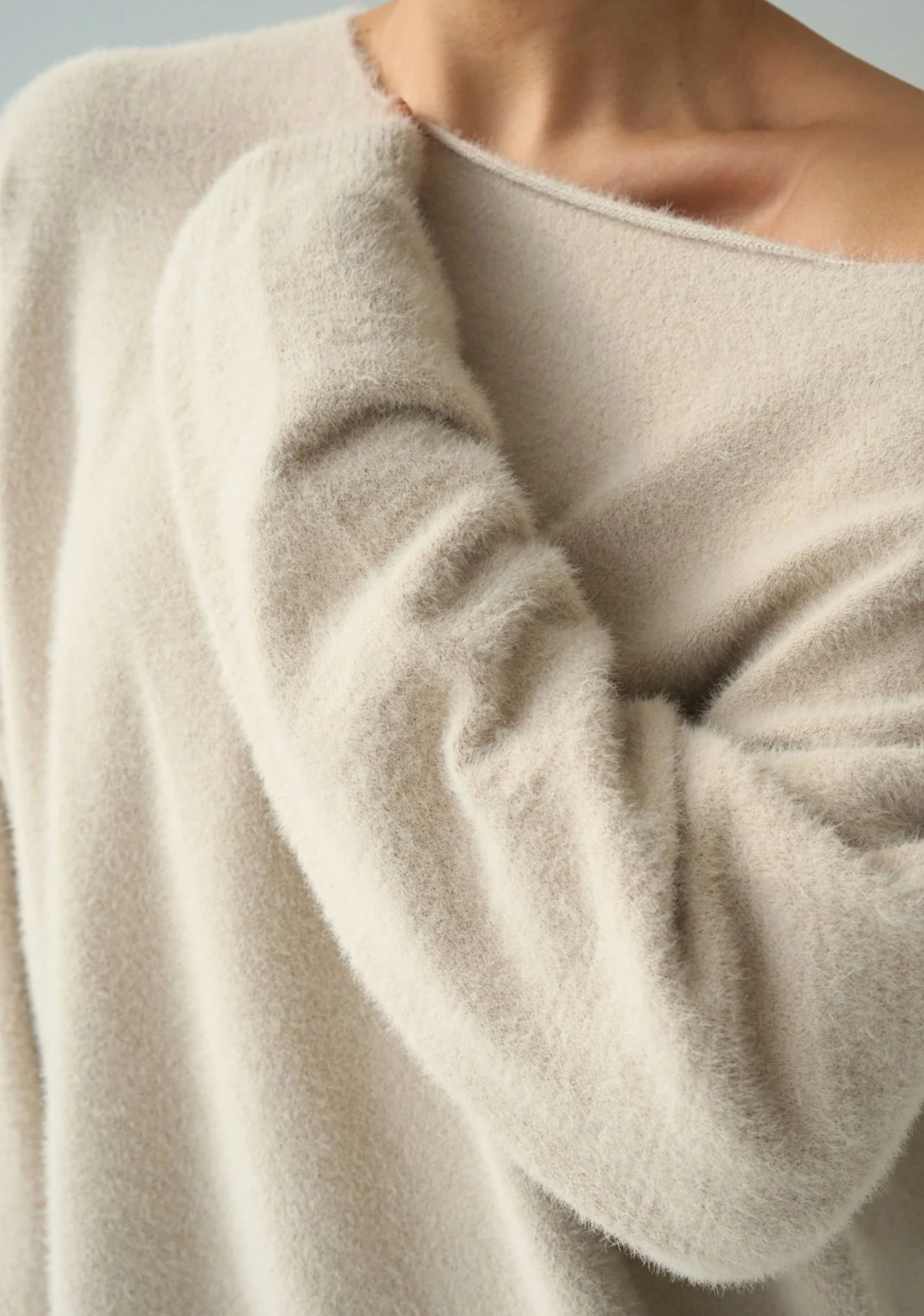 Cream off-shoulder fuzzy jumper showing soft texture and neckline