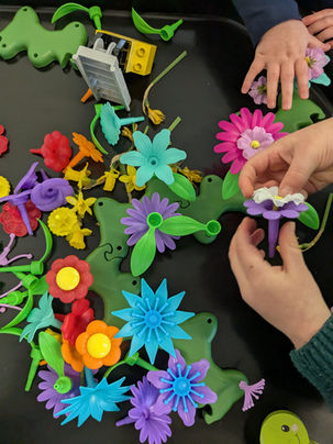 Childrens hands playing with plastic flower toys that fit together