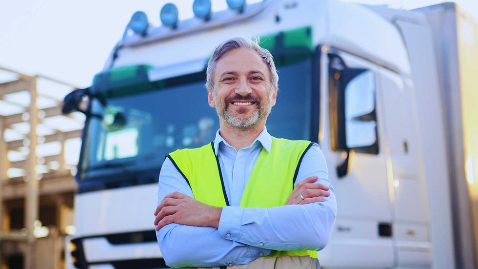 Bild von einem LKW-Fahrer, der vor seinem LKW steht.