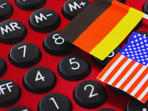 deutsche flagge und us-amerikanische flagge liegen auf einem taschenrechner