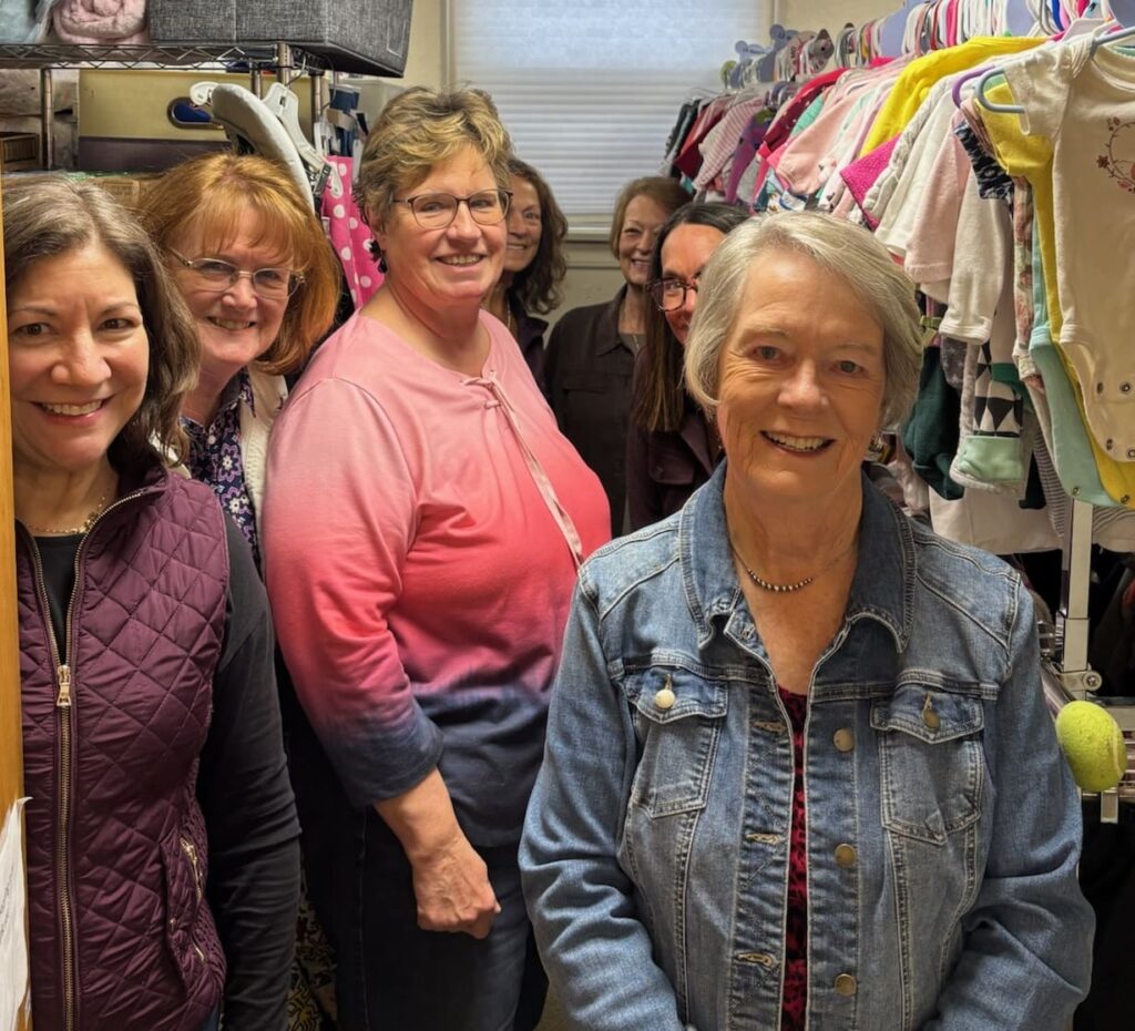 Marisol Family volunteers among racks of children’s clothing at St. Joseph in Fort Collins.