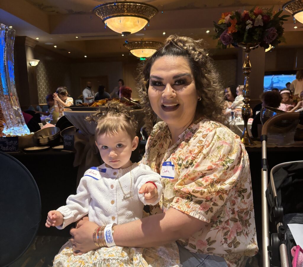 An adult holding a child at the Marisol Homes alumni Easter brunch.