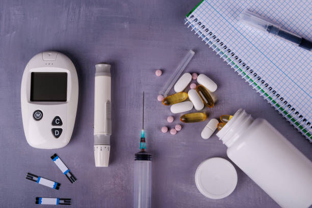 Medical items on a purple surface: blood glucose monitor, test strips, syringe, lancet, pills, and open notebook. Clinical setting.