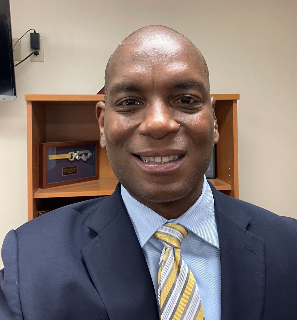 Portrait of a bald man wearing a suit and tie.
