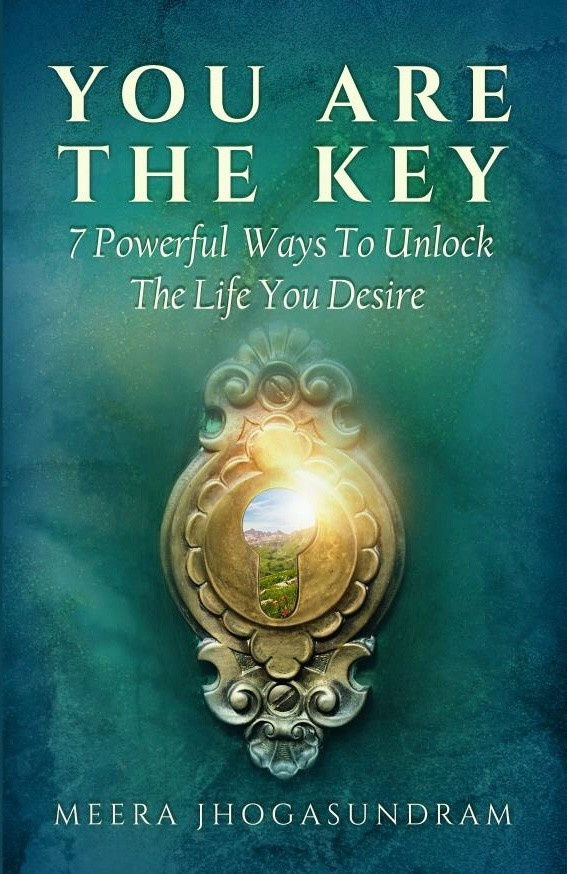 Book cover with a keyhole showing a sunny landscape. Text reads: "YOU ARE THE KEY: 7 Powerful Ways To Unlock The Life You Desire" by Meera Jhogasundram.