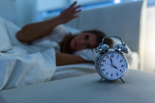 woman lying in bed suffering from insomnia