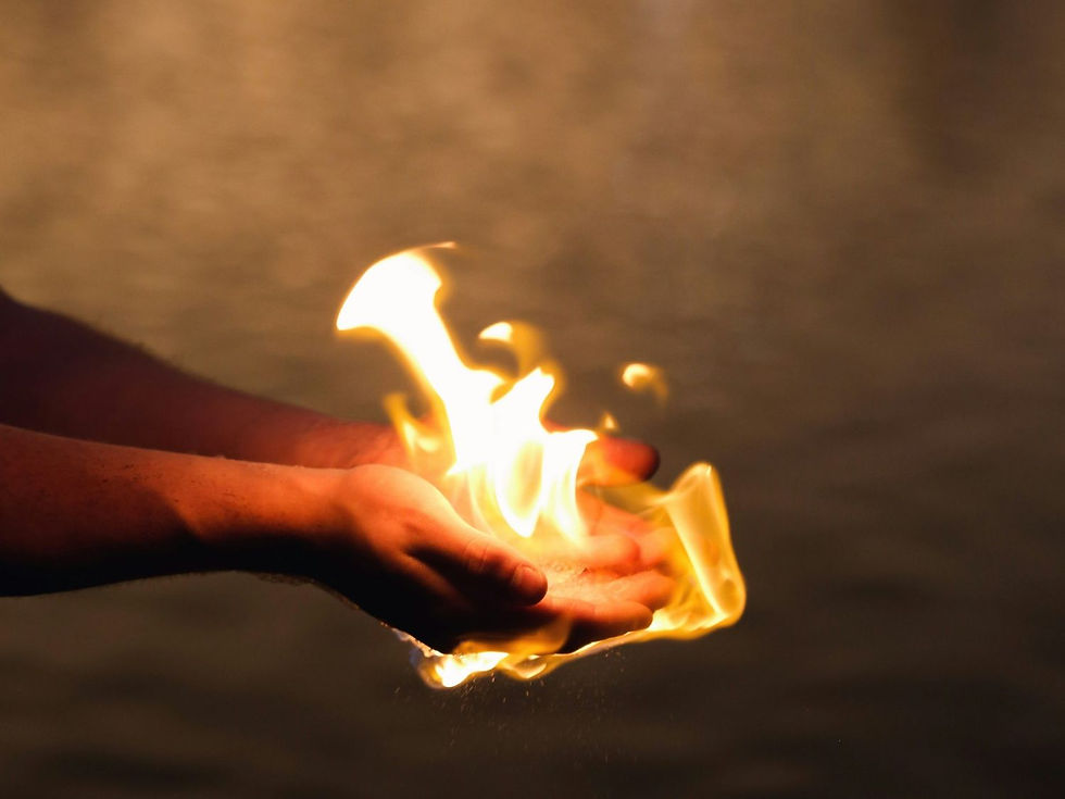 Hands cupping a bright flame, set against a blurred dark background, creating a dramatic and intense atmosphere.