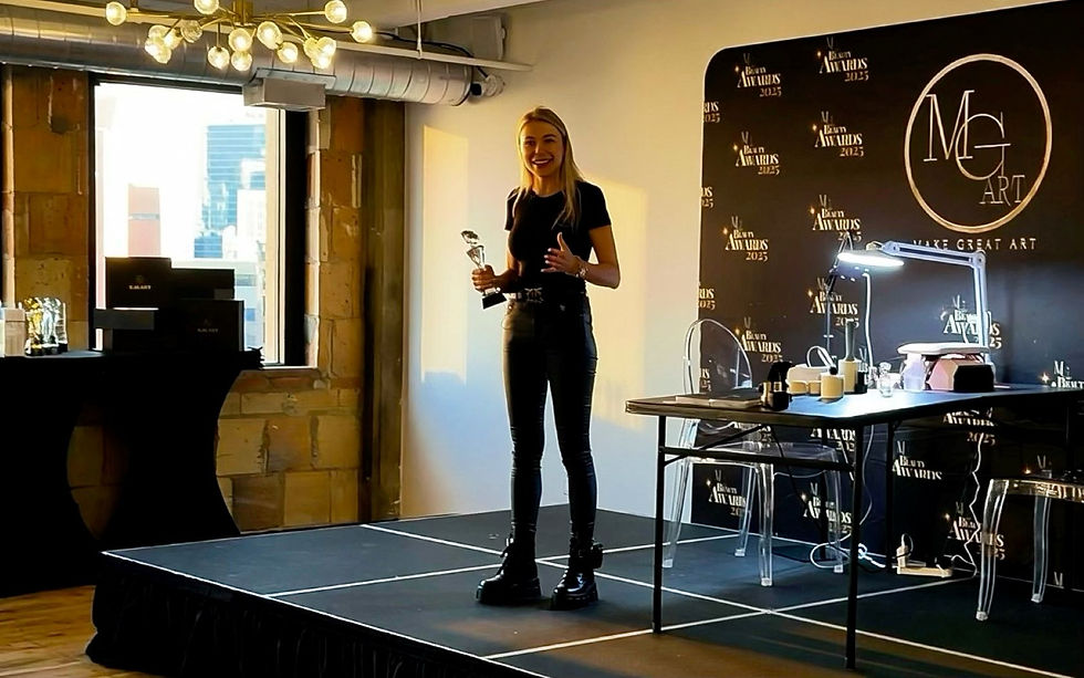 Woman holding a trophy on stage, smiling at a beauty awards event. Black attire, sleek décor, and branded backdrop. Bright lighting.