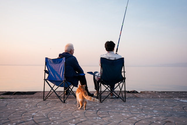 a man and a woman sitting in lawn chairs with a dog