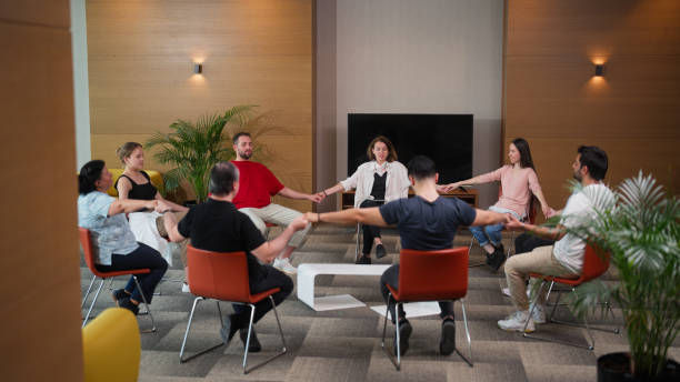 female group therapy professional is leading a group therapy session and meditating.