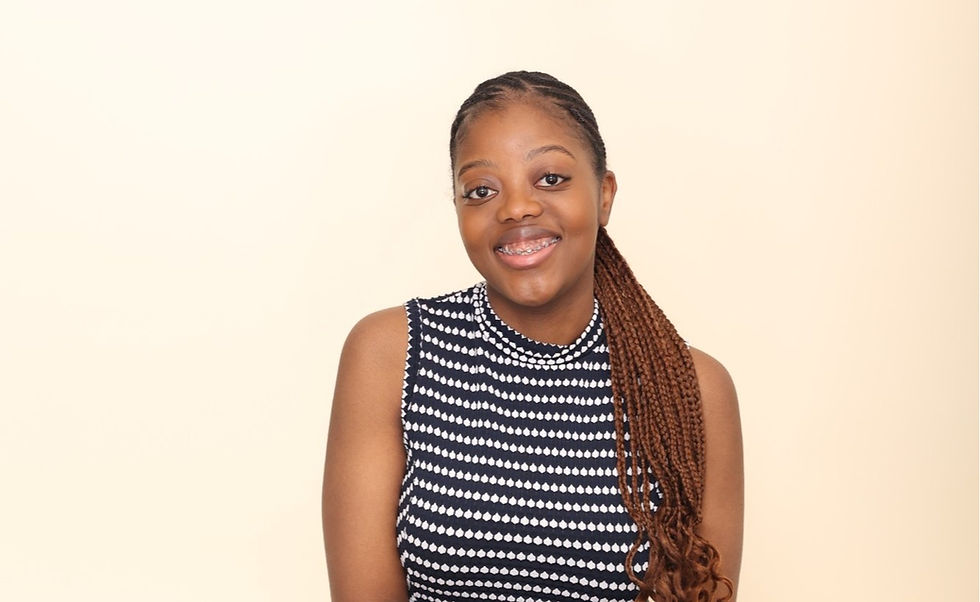 Smiling woman with braided hair, wearing a black and white patterned sleeveless top, against a light beige background. Mood is cheerful.