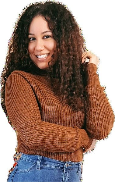 Smiling woman with curly hair in a brown sweater and blue jeans, set against a plain white background. Casual and happy mood.