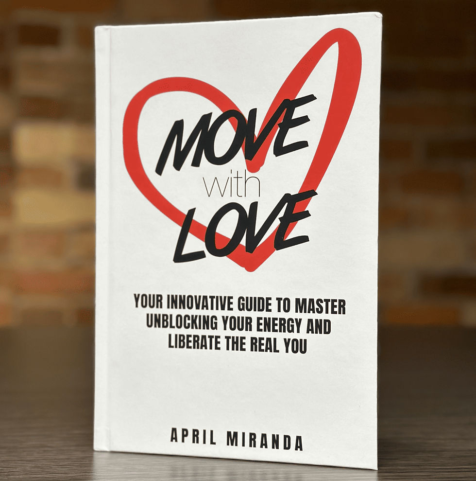 Book titled "Move with Love" by April Miranda, featuring a red heart and bold text. Background shows a blurred brick wall.