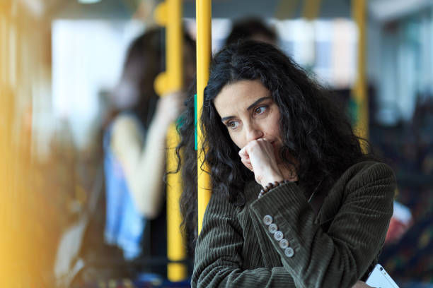 Pensive young woman traveling with bus and holding smart phone.