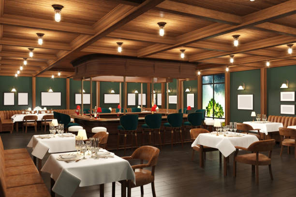 Empty upscale restaurant with wood ceiling, green walls, set tables and bar stools under warm hanging lights