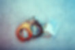 Handcuffs beside a $100 bill and a bag of white powder on a blue-gray surface, suggesting drug crime and arrest.