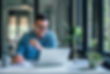 Lovely business man, attending a meeting online, writing stuff down