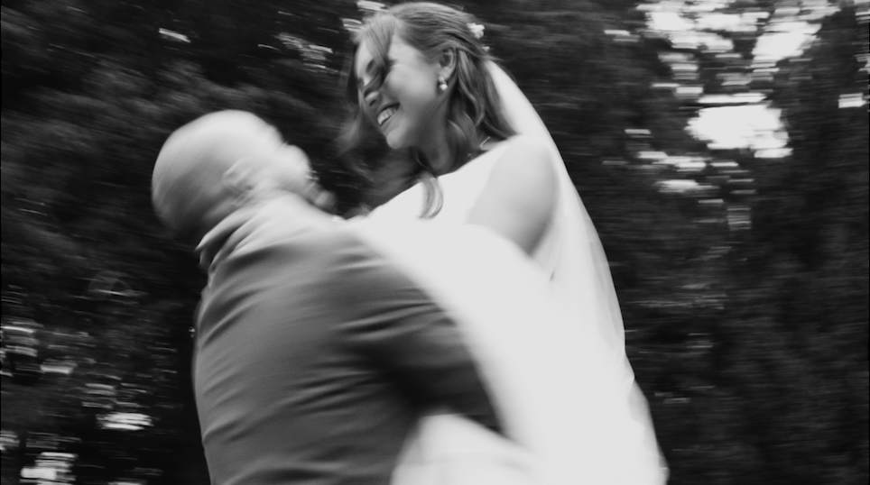 A joyful moment captured as the newlywed couple spins with pure happiness on their wedding day.