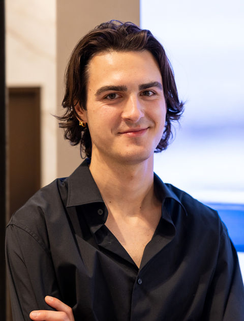 Smiling young man with dark hair, wearing a black shirt