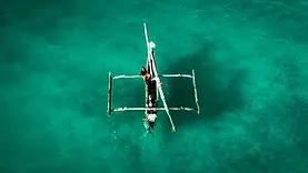 Ngalawa au large de Michamvi Kae à Zanzibar vu du ciel sur une eau turquoise limpide.