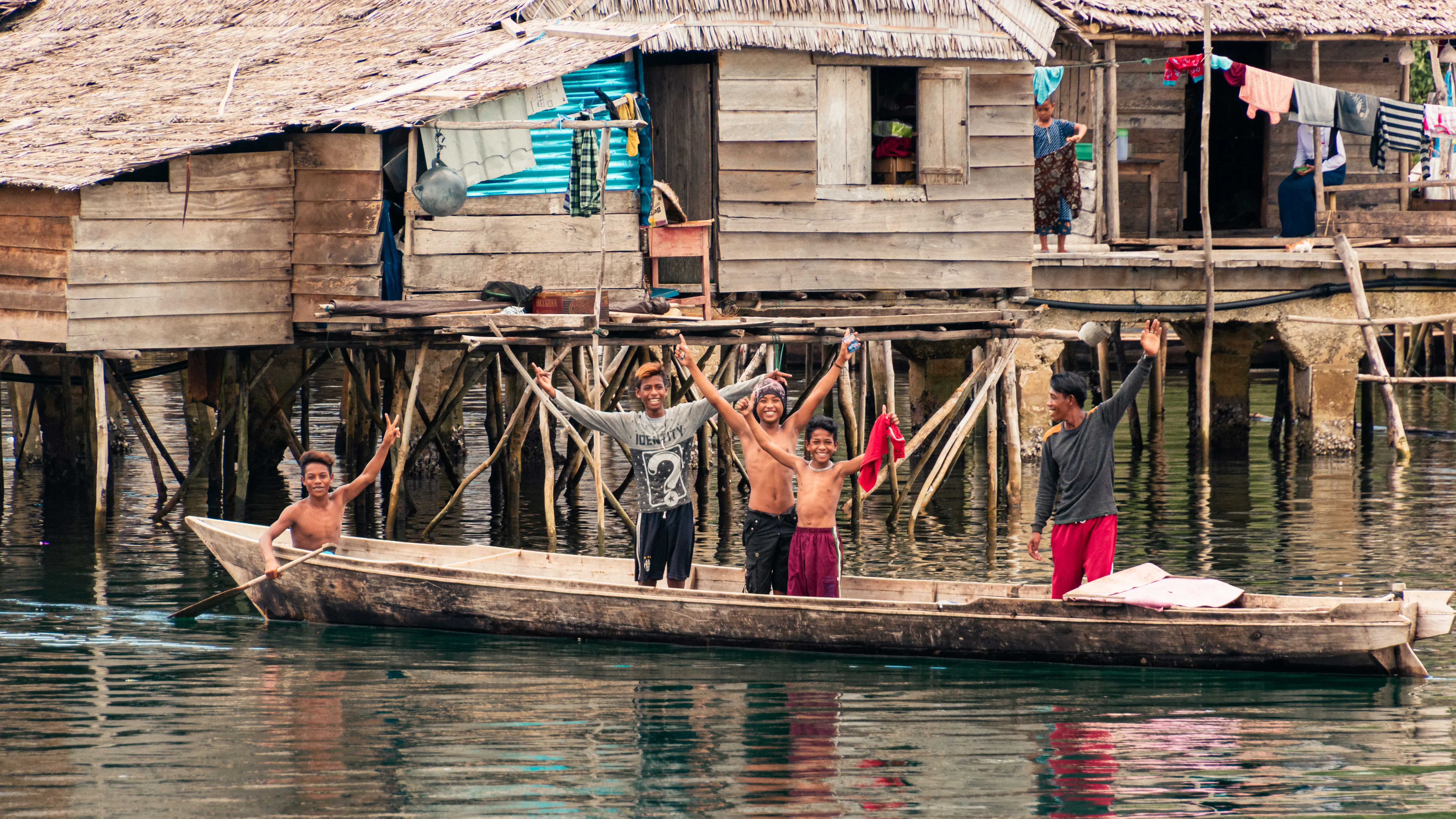 Enfants d’un village bajo dans une barque sur l’eau aux îles Togian en Sulawesi.