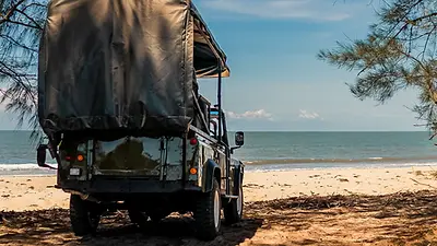 4x4 arrivant sur une plage entre brousse et océan dans le parc de Saadani