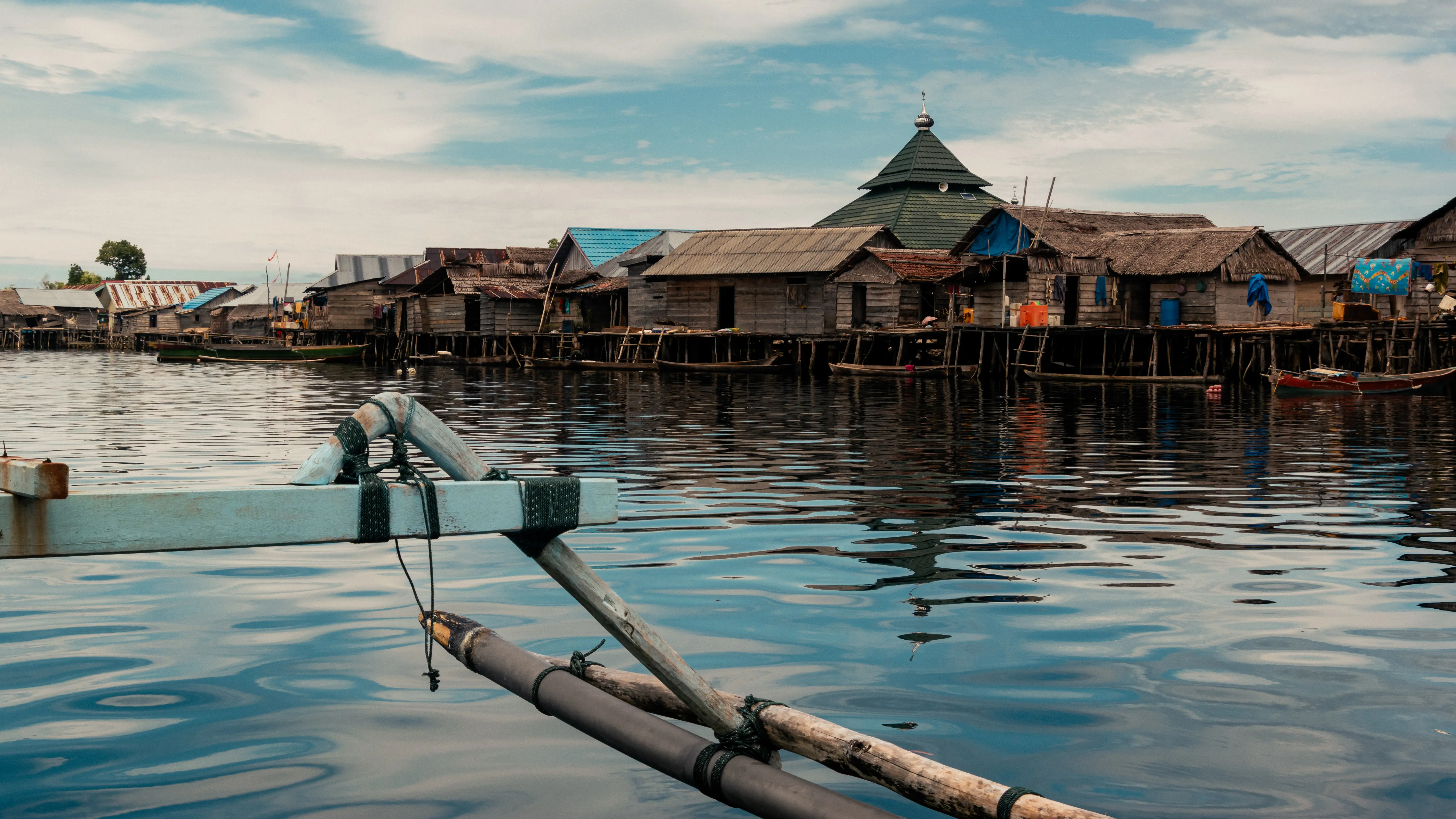 Bateau approchant un village bajo sur l’eau aux îles Togian en Sulawesi.