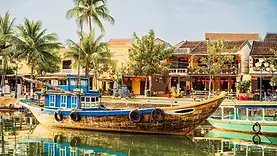Barque sur la rivière de Hoi An devant les façades de la vieille ville du Centre Vietnam