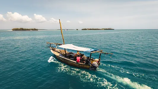 Dhow traditionnel naviguant sur les eaux calmes de Zanzibar dans la baie de Menai