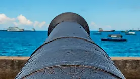 Canon tourné vers l’océan Indien à Stone Town avec vue sur la mer et les bateaux au large de Zanzibar.