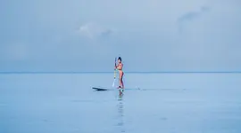 Voyageuse seule sur une eau calme à Pemba, symbole d’un rythme de voyage plus juste