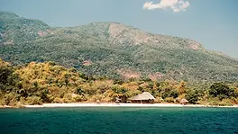 Plage du lac Tanganyika avec lodge, rive sauvage et montagnes de Mahale en arrière-plan