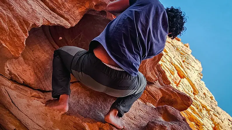Voyageur escaladant les roches du Sinaï dans un canyon en Égypte