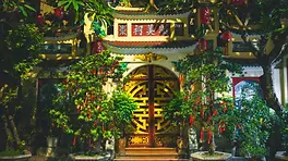 Temple illuminé de nuit à Hanoï entre lanternes, végétation et mémoire vietnamienne
