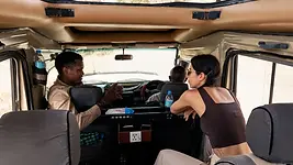 Guide expliquant la brousse depuis un 4x4 dans le Serengeti en Tanzanie pendant un safari privé.