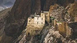 Village traditionnel accroché à une falaise dans les montagnes du Ladakh illustrant une expérience confidentielle et isolée