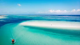 Lagon bleu de Pingwe à Zanzibar entre hauts-fonds, dégradés turquoise et rivage de l’océan Indien.