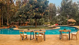 Vue du lodge de Mtoni River près d’Arusha avec piscine, jardin tropical et atmosphère paisible en début de voyage.