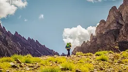 Randonneur dans une vallée minérale de l’Himalaya ladakhi, entre roches, sentier et altitude.