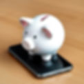 A piggy bank stood on a mobile phone.jpg