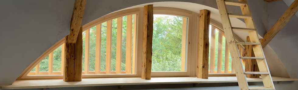 Hochwertiger Dachstockausbau eines historischen Berner Bauernhauses: Das massgefertigte Fenster nimmt elegant die Form der traditionellen Ründe auf.