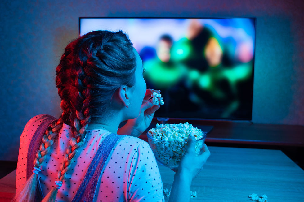 A girl watching a film on a projector screen and eating popcorn
