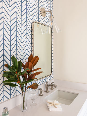 Providencia-Guest Bath, Guest bath, white shaker cabinets, white counters, white penny round tile, penny round flooring, designer guest bath, all white bathroom, silestone counters, quartz counters. Silestone white storm, kohler faucet, kohler margaux faucet, polished nickel finish, custom cabinetry, Benjamin Moore Chantilly Lace, circa lighting, wall sconce, Katie small conical sconce,, clear glass sconce, bathroom wall sconce, custom remodel, high end bathroom design. Rejuvenation, rejuvenation mirrors, wall paper, serena and lily feather wallpaper, denim wallpaper, cb2 hardware, round polished nickel handles, Contour knob brushed nickel.