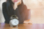 woman looking at a clock, waiting until the long term disability elimination period is over