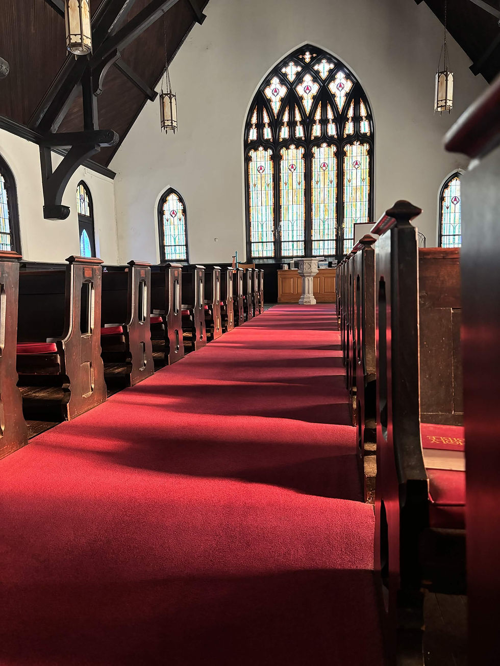 Church aisle with red carpet and stained glass window