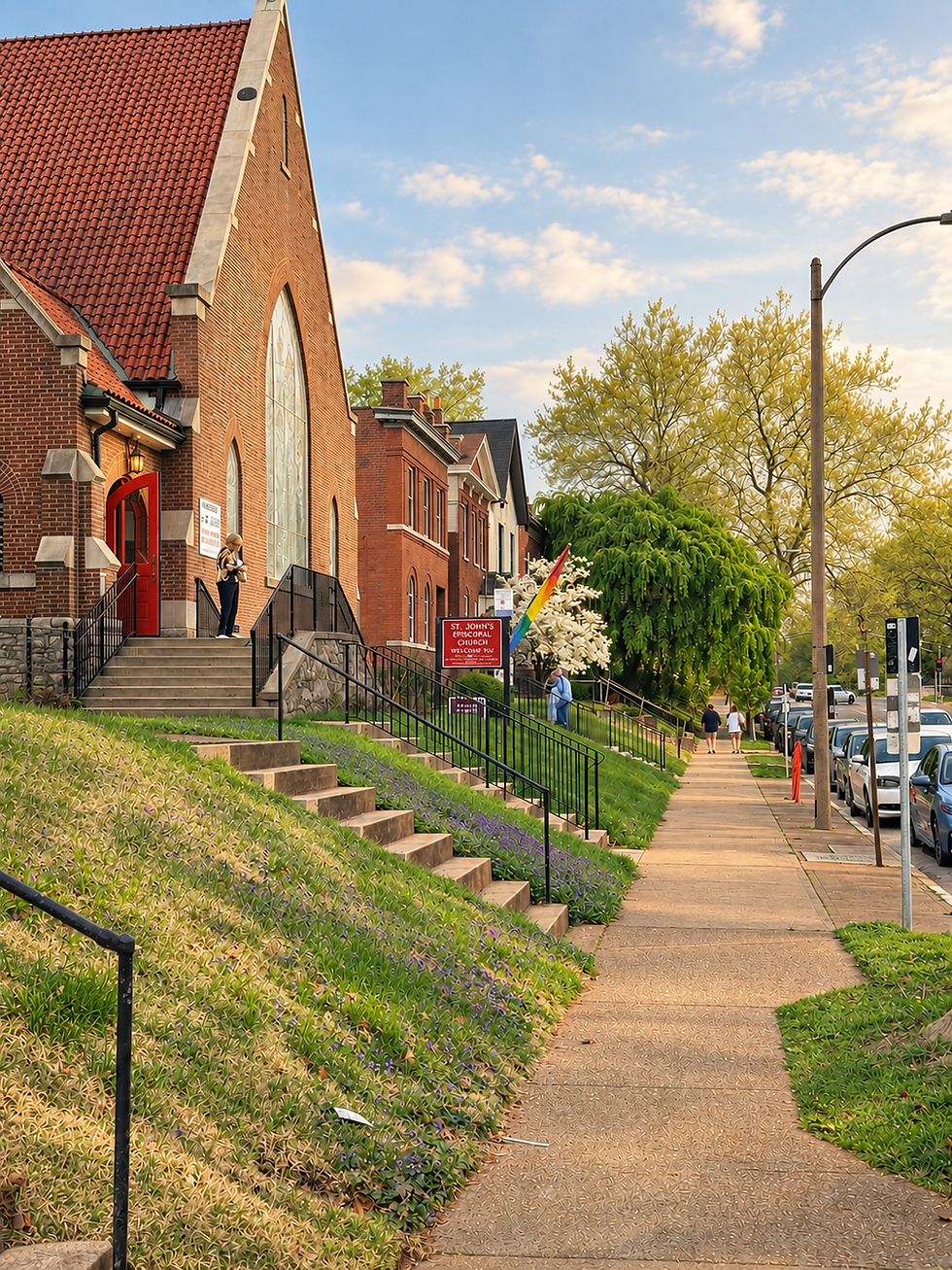 The front of St. John's -- a brick church with stained glass and a rainbow flag on a spring day